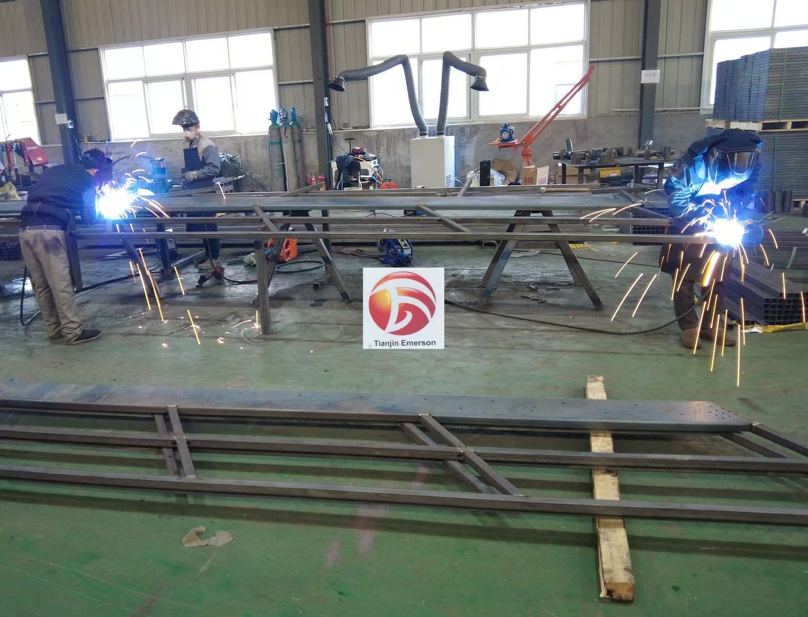 Factory workers welding steel rack